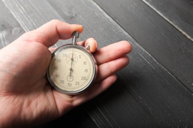 Kronometre ahşap arka plan üzerinde tutan kişinin yakın çekim 