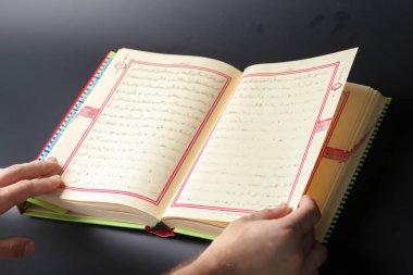 Kur'an - Müslümanların kutsal kitabı tutan adam