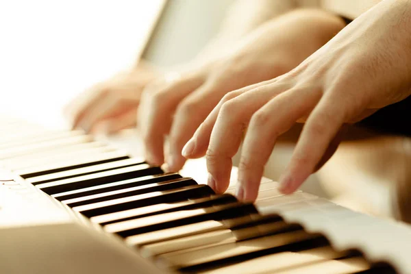 Closeup of hands playing piano. Music and hobby concept