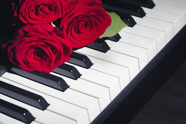 ピアノの鍵盤を赤いバラ — ストック写真