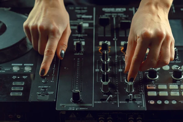 close up of DJ playing music at mixer