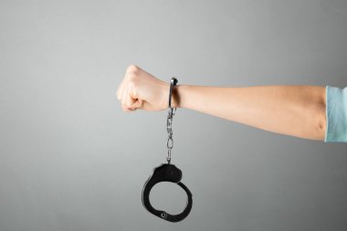 el ile kelepçe gri bir arka plana dayanır yakın çekim 