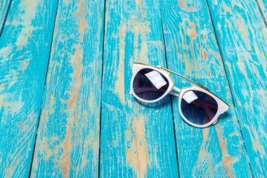 mavi ahşap arka plan üzerinde güneş gözlüğü