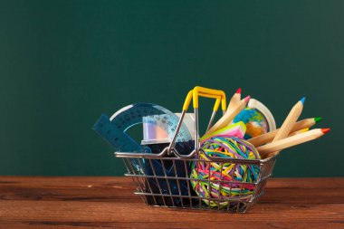 Ahşap bir masa ve tahta arka plan üzerinde okul malzemeleri