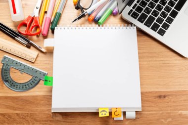 Not defteri ve ahşap masa üstünde laptop