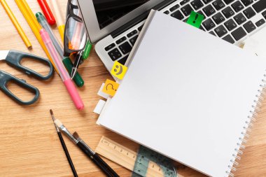 Not defteri ve ahşap masa üstünde laptop