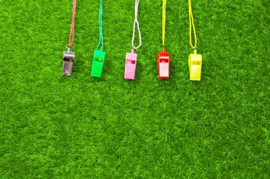 yeşil çimenlerin üzerinde satırda renkli ıslık çalar hakem