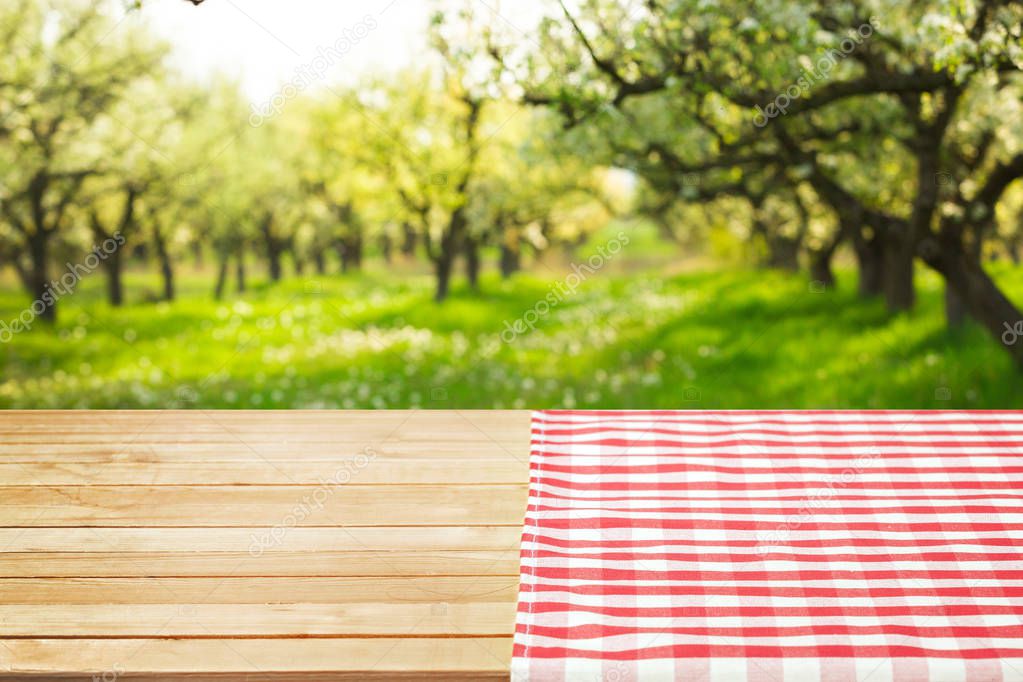 close-up shot of wooden table with red napkin on meadow