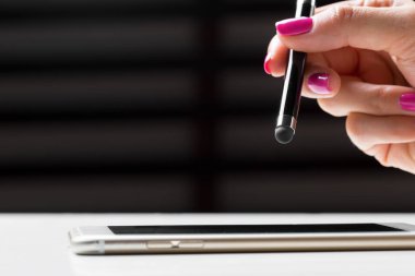 akıllı cep telefonunda kalemle çalışan kadın