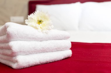 Bir otel odasında çiçek dekorasyonu ile havlu yığını