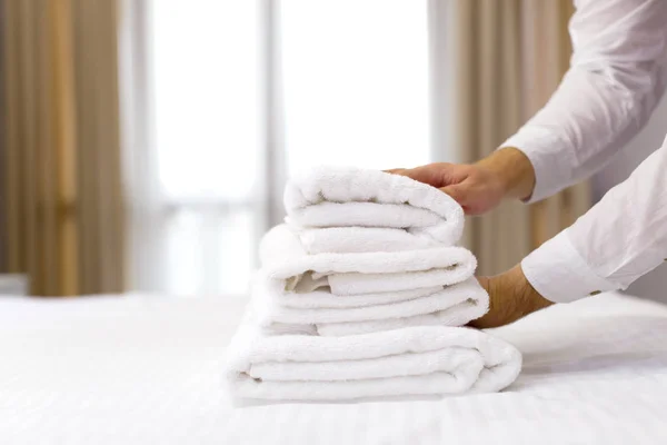 hotel staff setting up pillow on bed