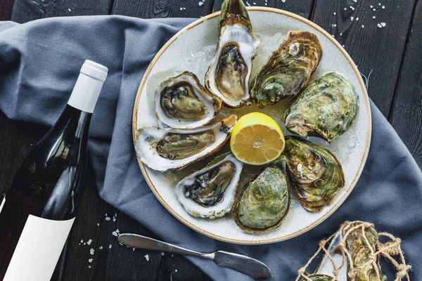 Open wet oysters on a plate with lemon