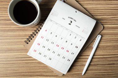 Çalışma alanı takvimi ile üstten görünüm ahşap arka plan üzerinde