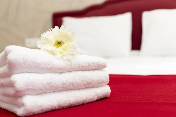 Stack of towels with flower decor in a hotel room