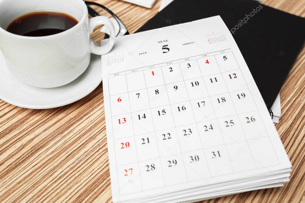 Top view of work space with calendar on wooden background