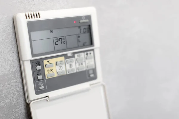 Air Conditioner Remote Control on white wall in hotel room