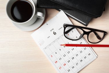 Kahve, takvim, gözlük ve kalem masa başında döşeme