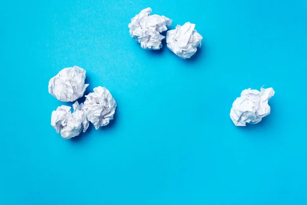 Balls of white paper on blue background
