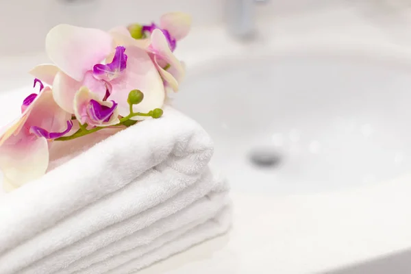 Stack of towels with flower decor in a hotel room