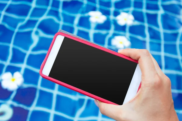 Smartphone with black screen near pool. Vacation concept