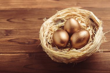 ahşap masa üzerinde altın yumurta