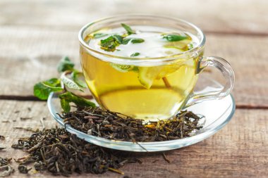 siyah çay nane ile ahşap bir masaya bırakır