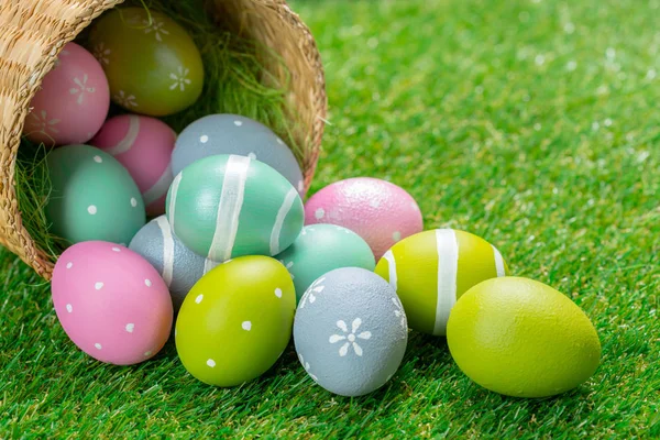 五颜六色的复活节彩蛋从篮子里倒在绿草上 — 图库照片