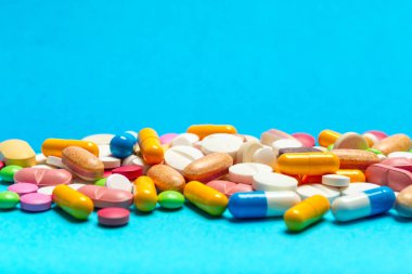 mavi arka plan üzerinde renkli hapları dağınık