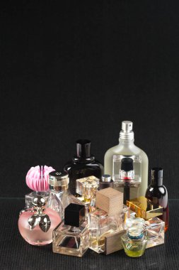 koyu arka plan üzerinde çeşitli parfüm şişeleri