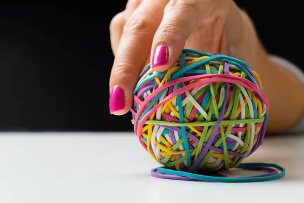 Woman\'s hand with colorful rubber bands ball