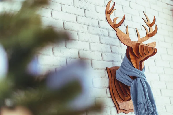 Decorative wooden Christmas elk with a scarf in interior