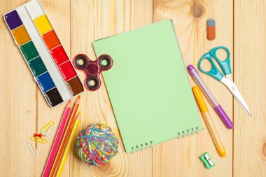 Tahta arka planda farklı okul malzemeleri var. 