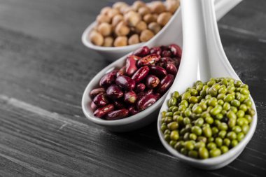 varicolored fasulye siyah arka plan üzerine kaşık karışımı