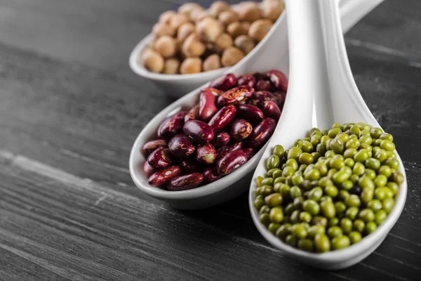 varicolored fasulye siyah arka plan üzerine kaşık karışımı