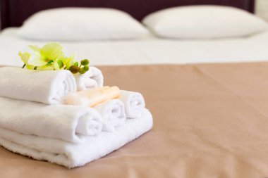 Otel odasında çiçek dekorasyonu ile havlu yığını