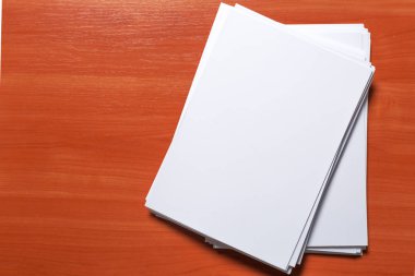 Ahşap masa üzerinde beyaz iş kartı. Boş dikey A4.