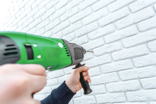 Use hammer drill to drill the wall