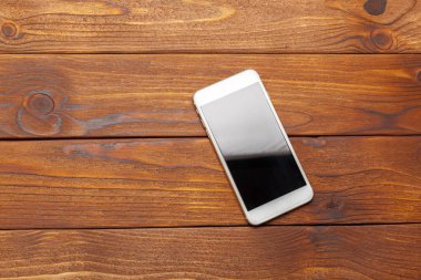 Ahşap bir masa üstünde hareket eden telefon 
