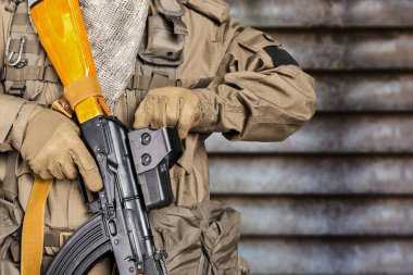 Kamuflajlı asker elinde tüfekle