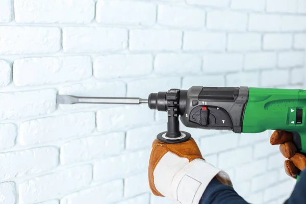 Use hammer drill to drill the wall