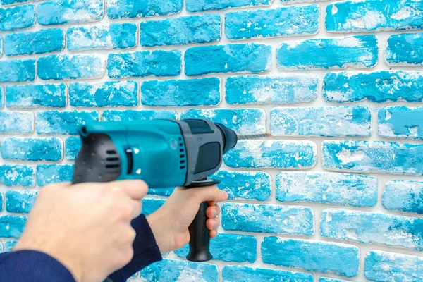 Use hammer drill to drill the wall