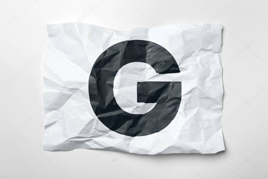 Grunge wrinkled paper letter G on white background