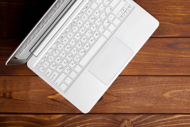 Laptop, defter üzerinde ahşap çalışma masası 