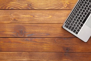 Laptop, defter üzerinde ahşap çalışma masası 