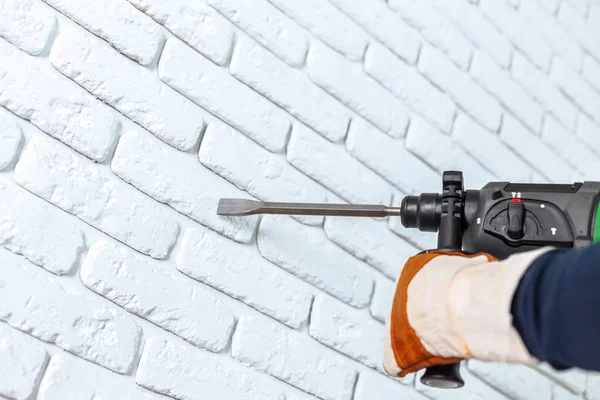 Use hammer drill to drill the wall