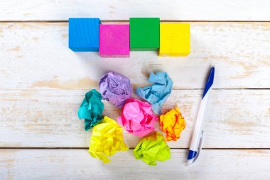 Ahşap bir masa üzerinde renkli buruşuk kağıtlar