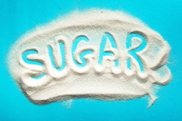 The word sugar written into a pile of white granulated sugar