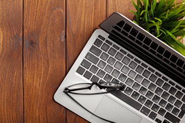 Laptop, defter üzerinde ahşap çalışma masası 