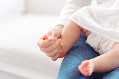 Genç anne ve yenidoğan bebek beyaz yatak odasında 