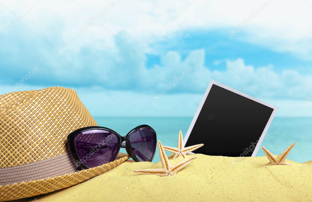 close up of hat and glasses on sand background
